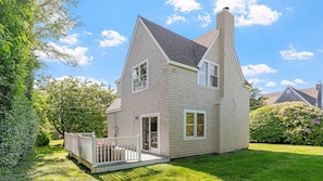 A two-story house with a gabled roof, a front porch, and a small deck. - Walk to Newport, 1st & 2nd Beaches, & Cliff Walk from this Newly Redone Home (Middletown)