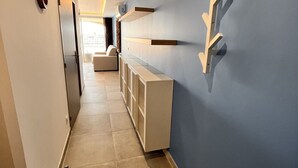 Un pasillo con una pared azul, un armario blanco y una puerta.