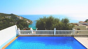 Una piscina con vista sul mare e un parapetto bianco.