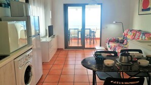 Una cucina funzionale con lavatrice, frigorifero e zona pranzo con tavolo e sedie.