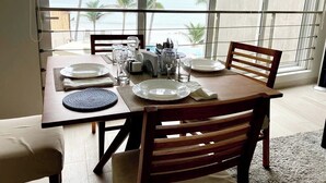 A dining table set for four with a view of the ocean.