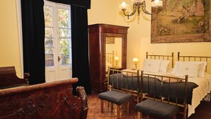 Un dormitorio con una cama de madera, una mesita de noche, un aparador y un espejo grande.