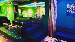 Un espace lounge moderne doté d’un bar, de sièges et d’une scène.