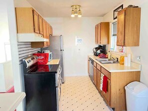 Enjoy cooking in this kitchen with a refrigerator, cabinets, and a tiled backsplash.