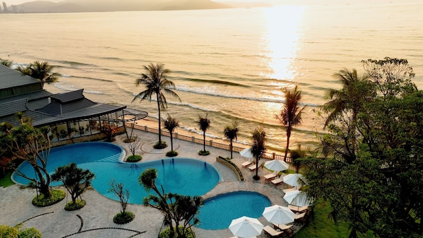 Un resort con piscina, playa y vista al océano.