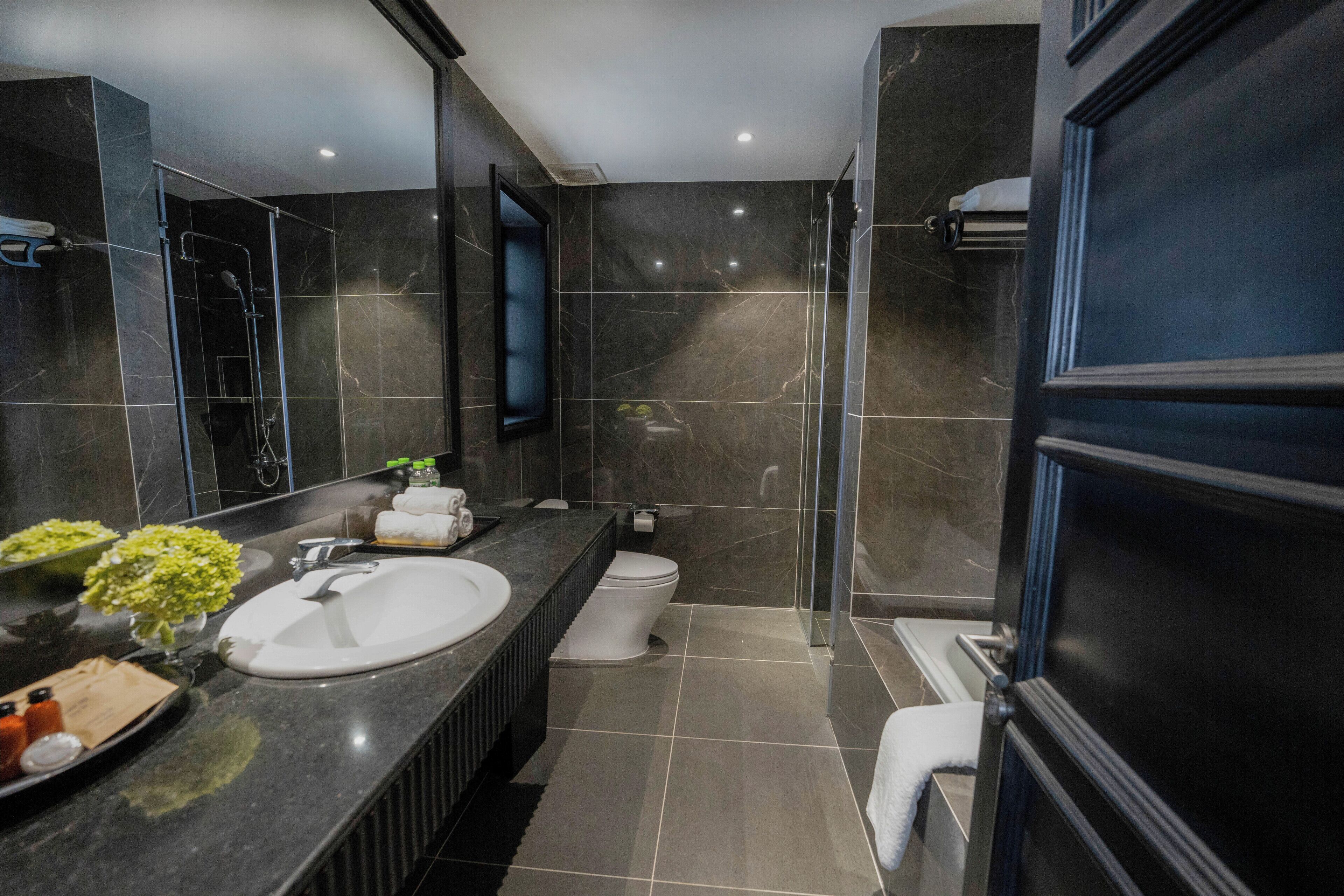 Un baño moderno con un lavamanos grande, inodoro y zona de ducha.