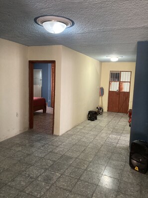 A spacious room with a tiled floor, a ceiling fan, a door leading to another room, and a window with blinds. - Casa campestre donde tocan suavemente los rayos del amanecer! Venga a R-E-L-A-X! (Balcones de la Calera)