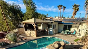 Un jacuzzi con sistema de filtración integrado, una piscina y un patio con mobiliario exterior.