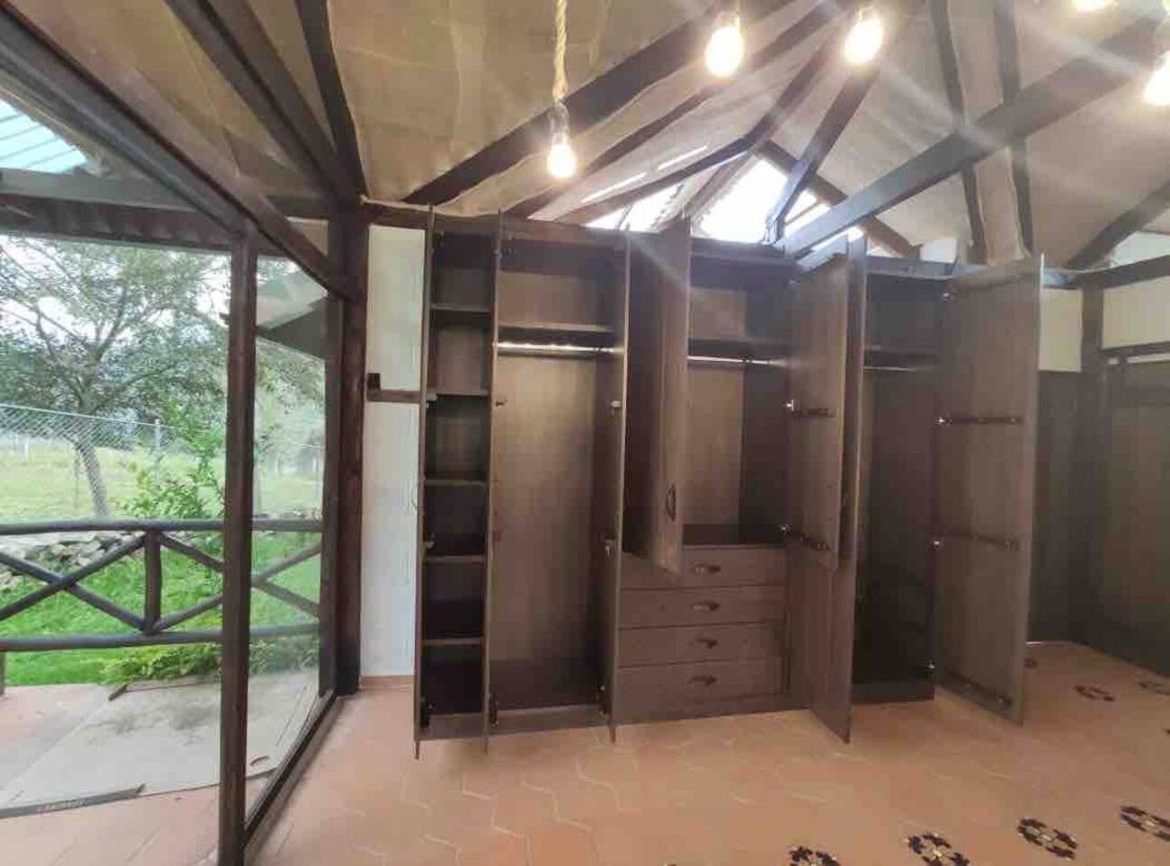 A room with a built-in wardrobe, a window, and a view of the outdoors.