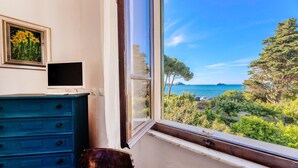 A room with a view of the sea, a dresser, a chair, and a framed picture on the wall. - Villino Rosa – mit Garten und Meerblick (Portoferraio)