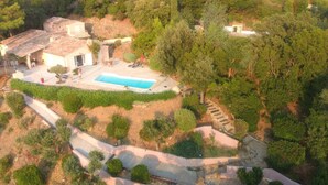 Vista aérea de una propiedad con piscina, un patio y una escalera que conduce a un edificio.