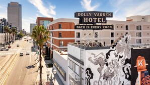 Das Dolly Varden Hotel mit einem Schild, auf dem 'Badewanne in jedem Zimmer' steht, und Blick auf die Straße sowie umliegende Gebäude.
