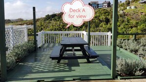 A deck with a picnic table and a white fence, surrounded by greenery and houses in the background. - Penelope garden ,5 min to Botany shopping mall (Auckland)