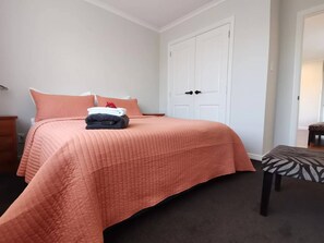 Cozy retreat with a large bed, plush quilted bedspread, and a stylish bench at the foot.