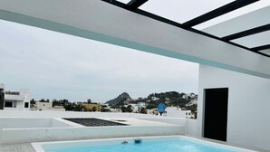 A rooftop swimming pool with a view of a mountain and buildings in the background. - Aleman 13, Central apartment near the beach (Mazatlán)