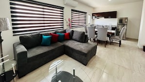 A modern living room with a sectional sofa, dining area, and kitchen. - Aleman 13, Central apartment near the beach (Mazatlán)
