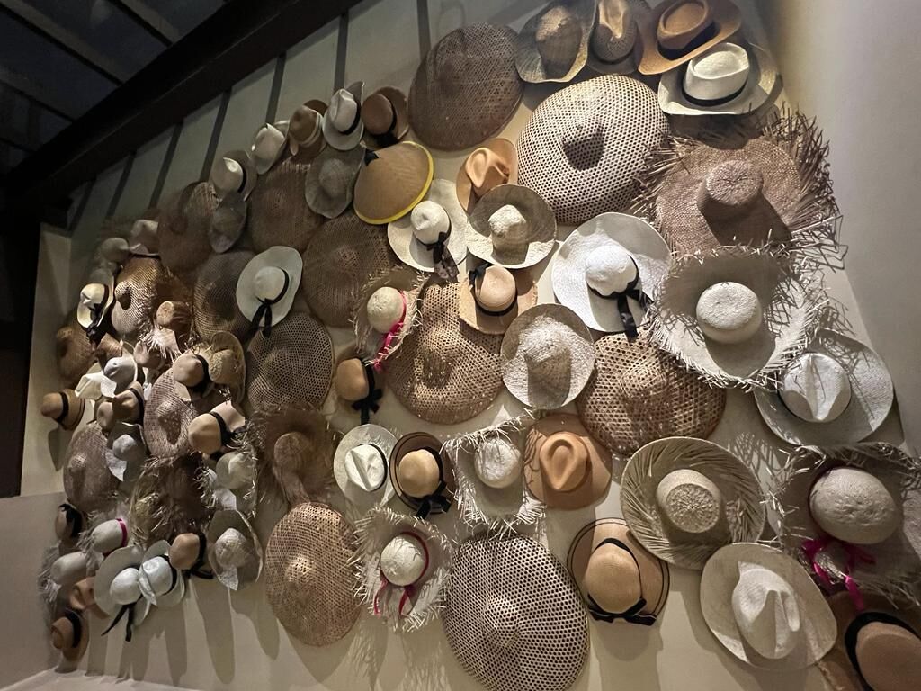 Una pared mostrando una variedad de sombreros.