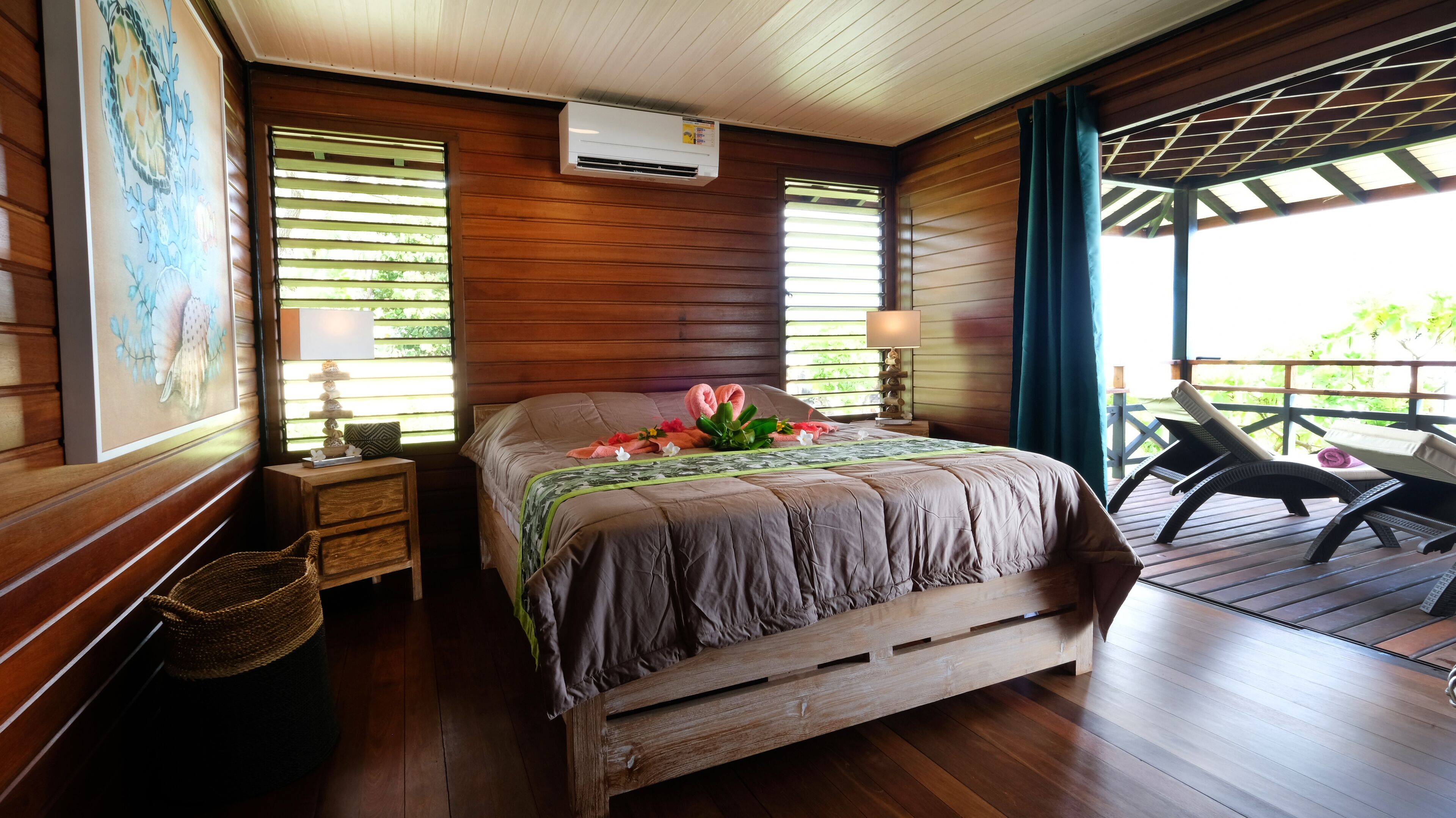 Une pièce aménagée comme un chalet en bois, avec un lit, une table de chevet, une lampe et une vue sur l’extérieur.
