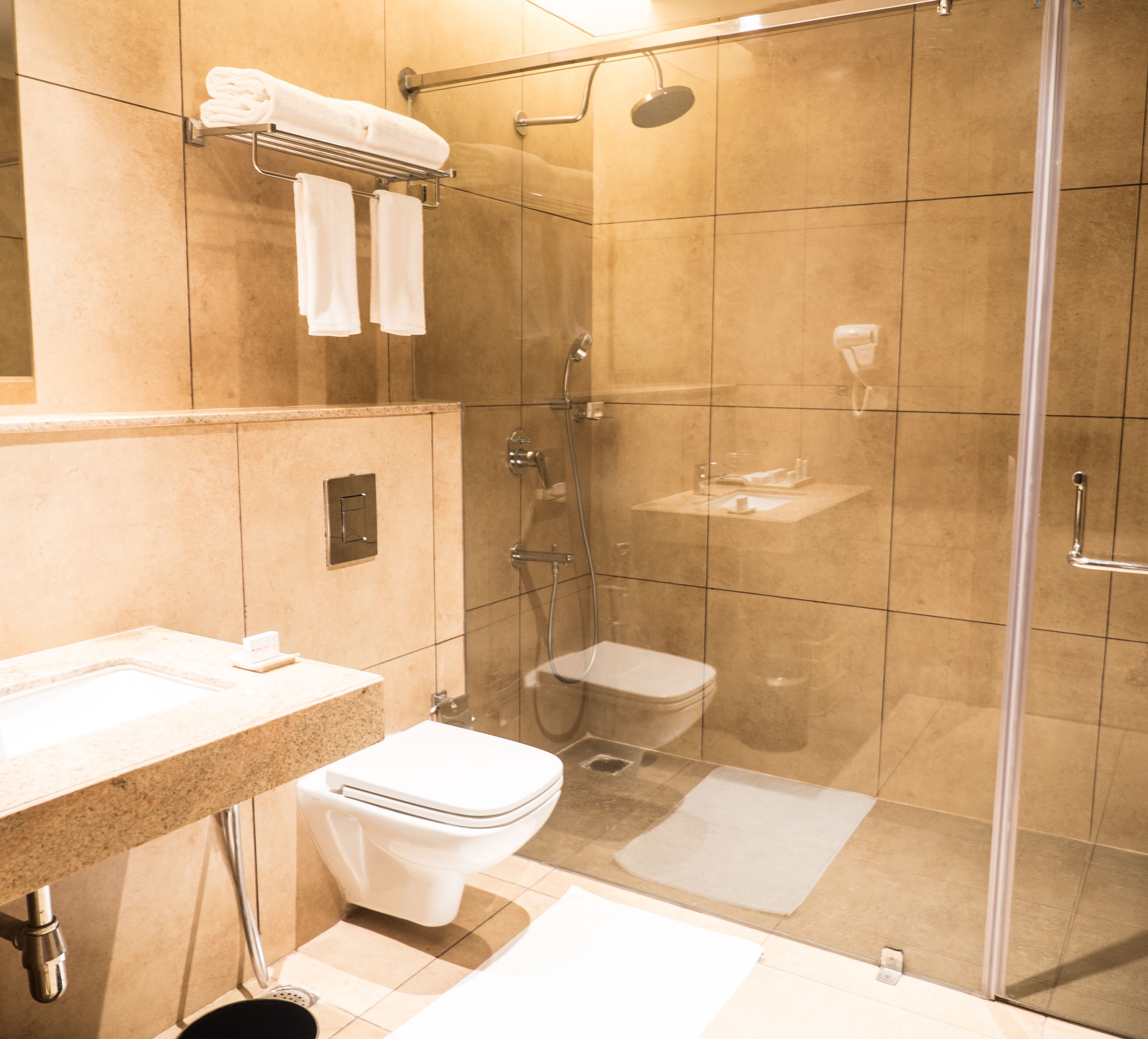 Un baño moderno con cabina de ducha de vidrio, inodoro y lavabo con encimera.