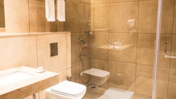 Un baño moderno con cabina de ducha de vidrio, inodoro y lavabo con encimera.
