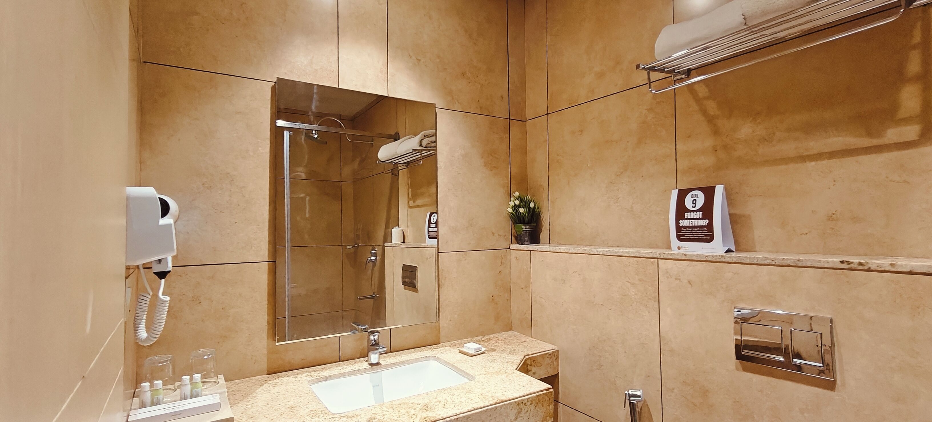 Une salle de bain moderne avec un grand miroir, un lavabo et un porte-serviettes.