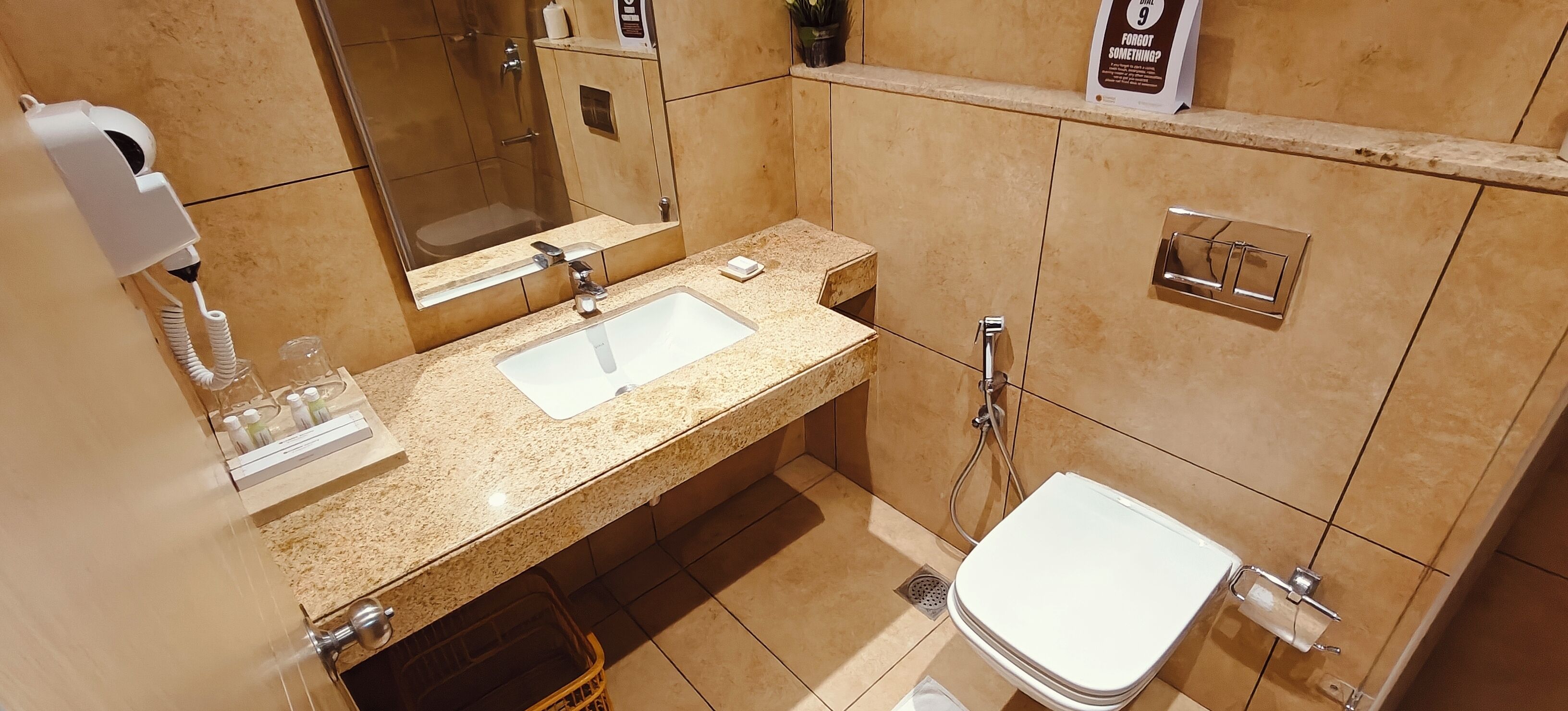 Ein Badezimmer mit Waschbecken, Spiegel, Toilette und Dusche.