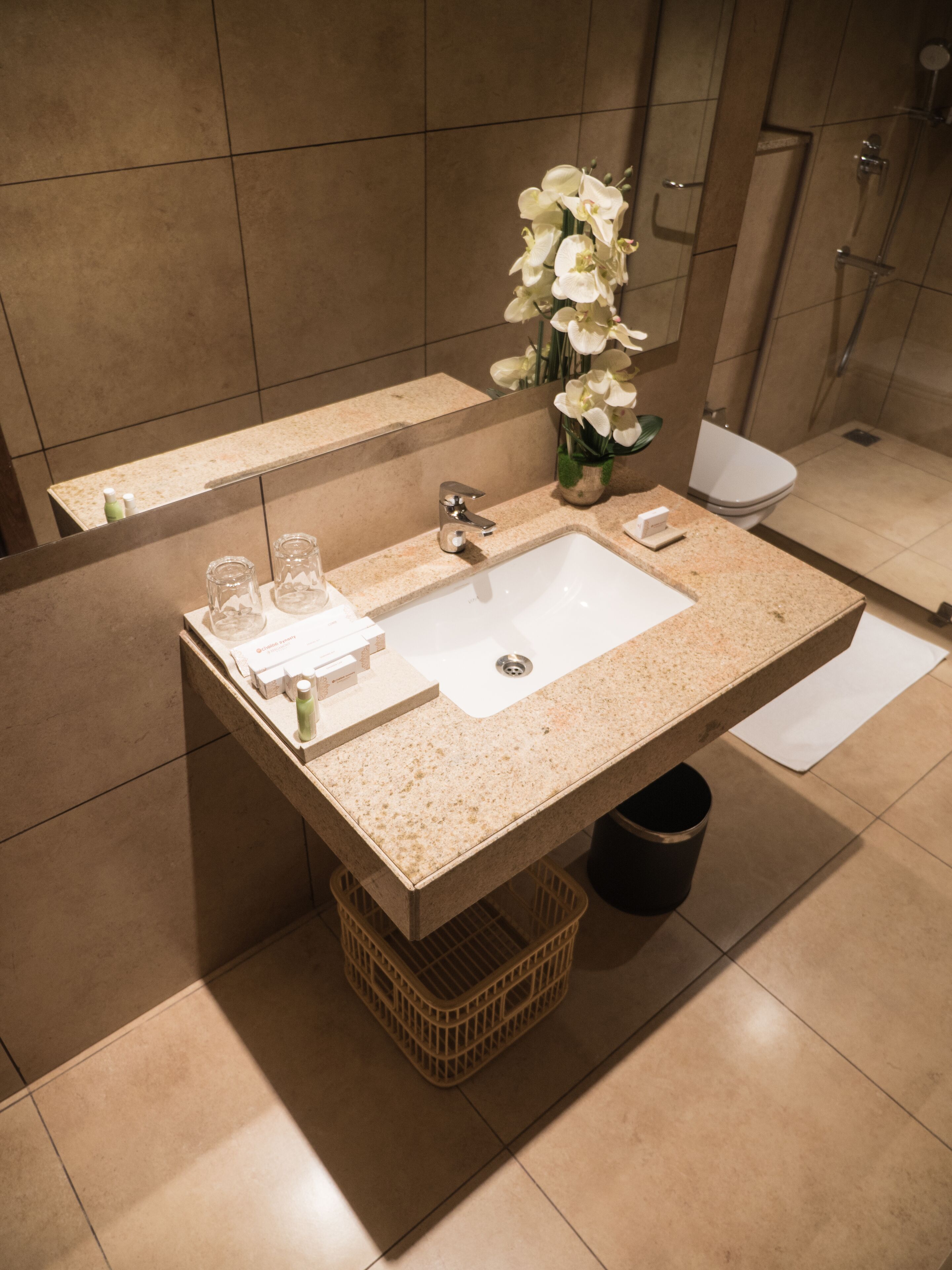 A modern bathroom with a large sink, a mirror, and a shower.
