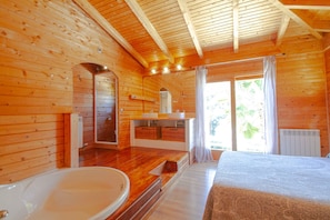 A wooden cabin with a bathroom featuring a bathtub, a sink, and a mirror. - Club Villamar - Rent your dream villa and spend an unforgettable holiday (Calonge)