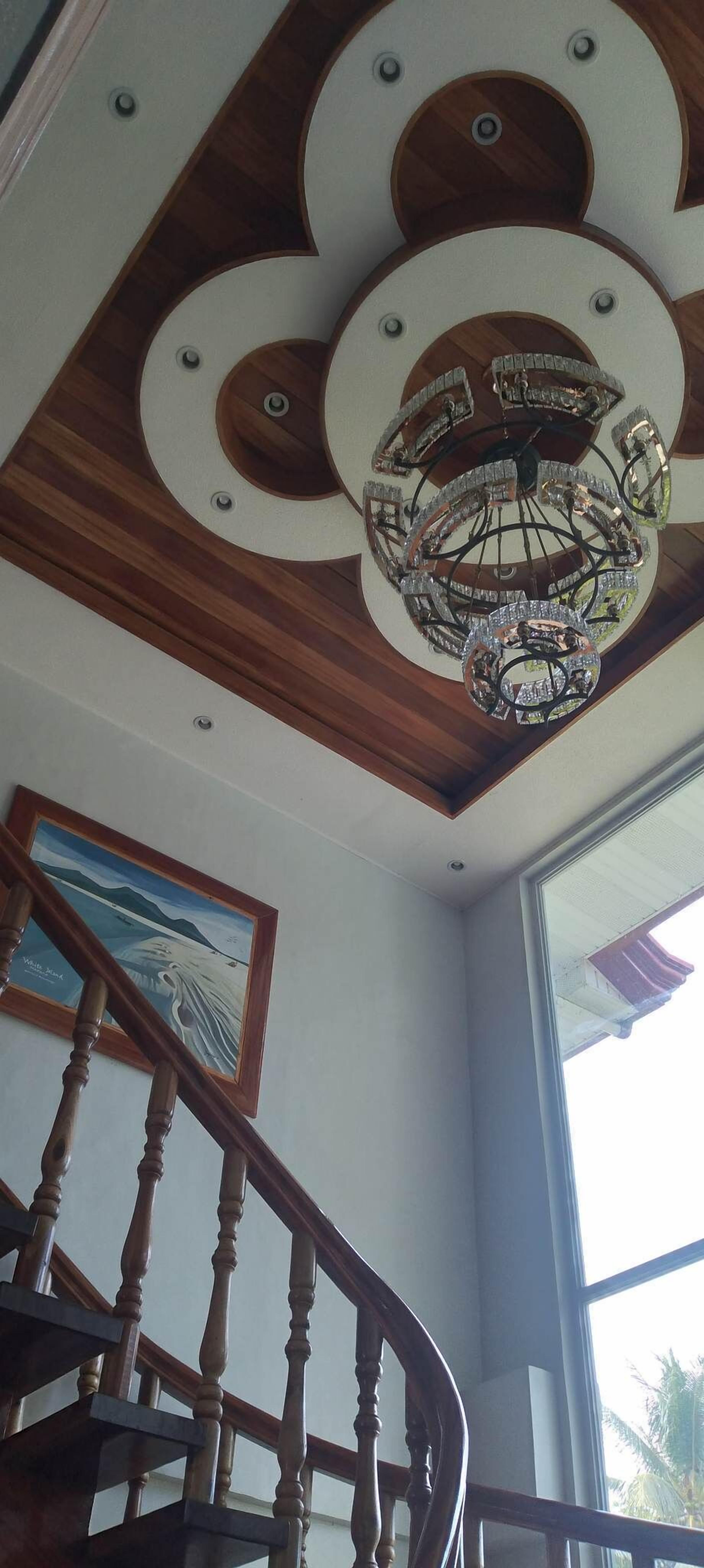 A wooden staircase with a chandelier.