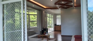 A spacious living area with a sofa, coffee table, and a view of the outdoors through large windows.