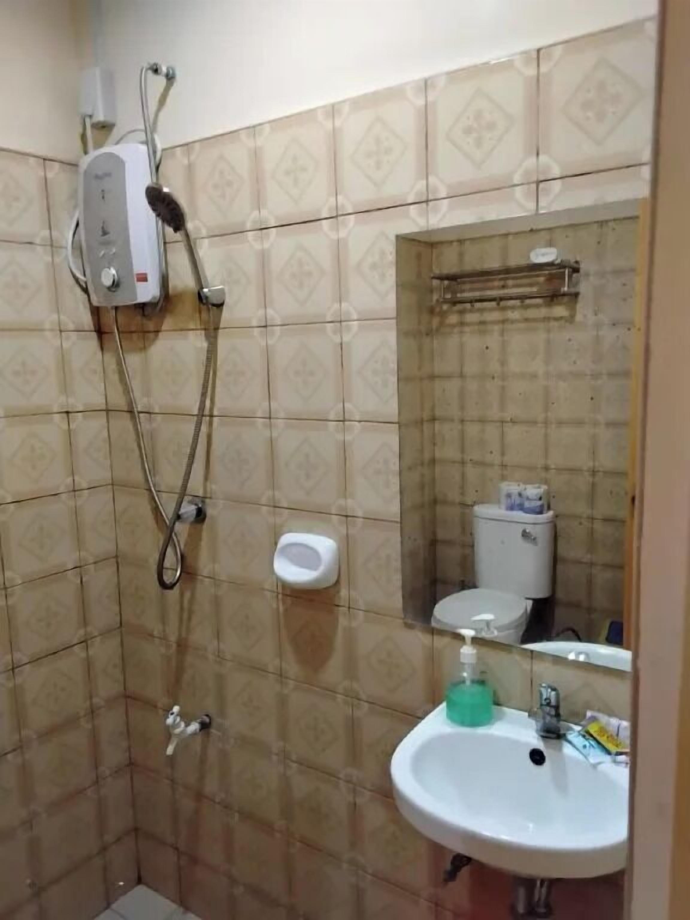A small bathroom with a shower, toilet, and sink.