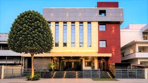 A modern building with a symmetrical facade, large windows, and a central entrance with steps. - Hotel Bhagyaraj Palace - Best Hotel In Kanpur (Kanpur)
