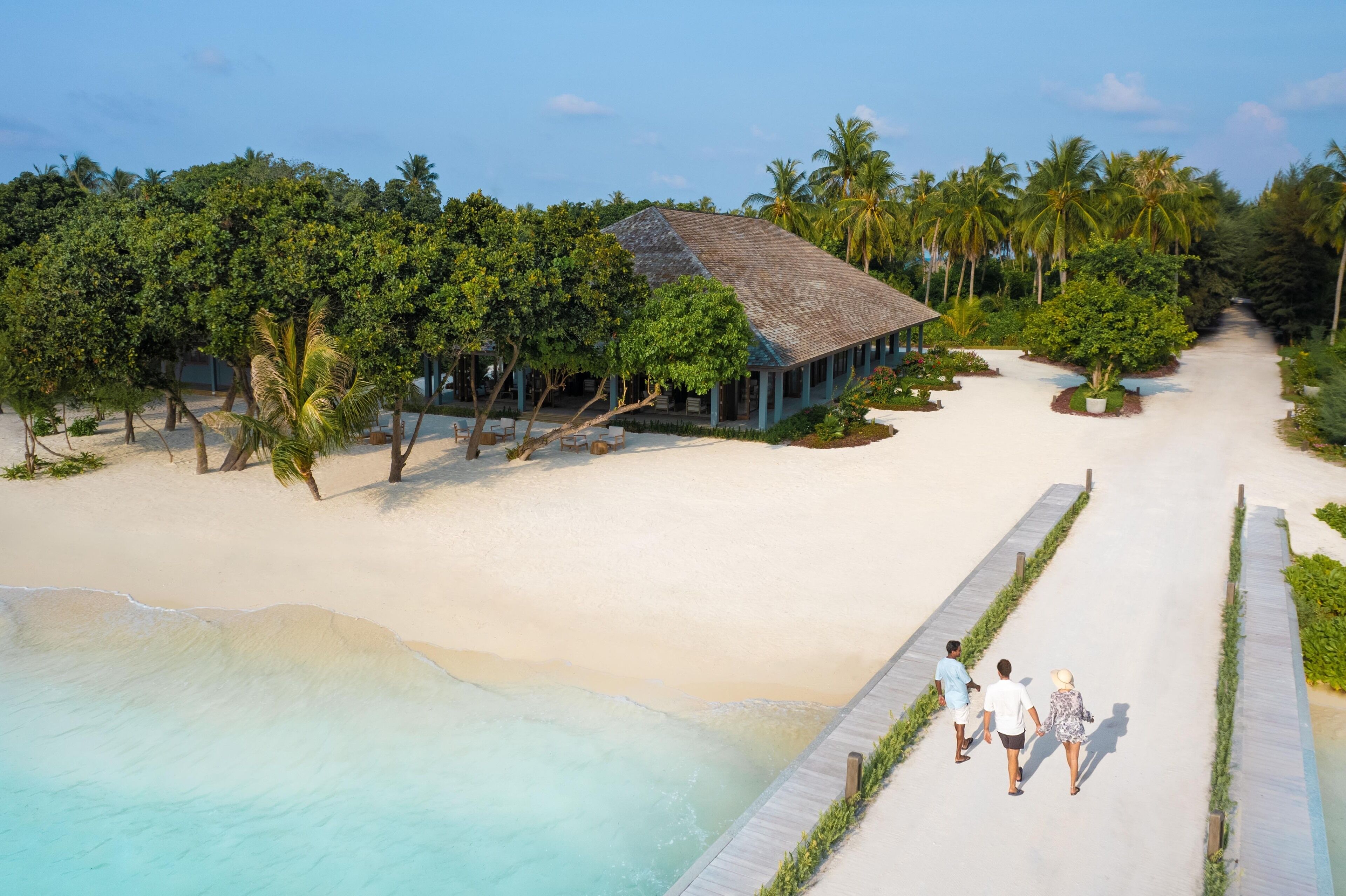 Un complexe hôtelier doté d’une plage, d’une piscine et d’un espace abrité agrémenté de palmiers.
