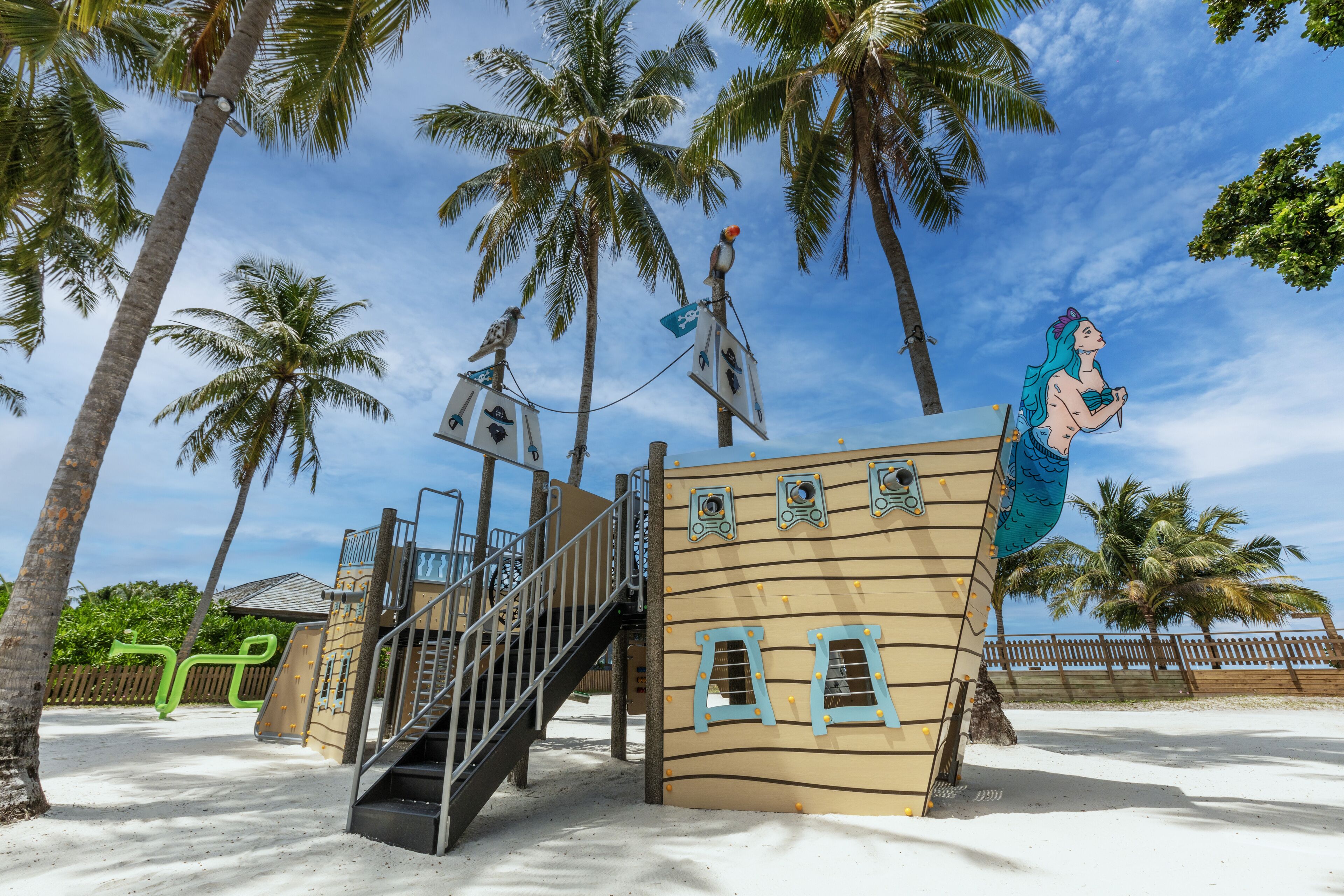 A children's play area with a pirate-themed structure, including a slide and climbing wall.