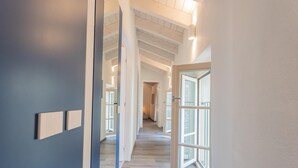 A modern interior with a wooden floor, white walls, and a large glass door leading to a balcony. - Muralto s Nest in Como (Como)