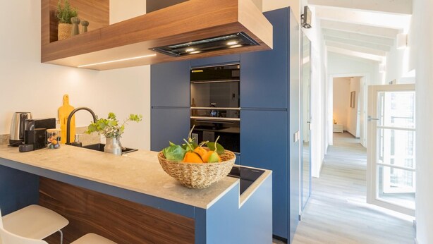 A modern kitchen with a built-in island, stainless steel appliances, and a basket of fruit. - Muralto s Nest in Como (Como)