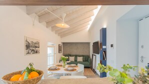 A modern kitchen with a dining area, a green sofa, and a basket of fruit on the table. - Muralto s Nest in Como (Como)