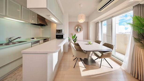A modern kitchen with a central island, a dining area with a table and chairs, and a large window providing a view of the outdoors. - CityLife miyako L'avenir (Miyakojima)