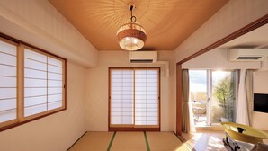 A traditional Japanese room with tatami flooring, sliding shoji doors, a ceiling fan, and a view of the outdoors. - CityLife miyako L'avenir (Miyakojima)