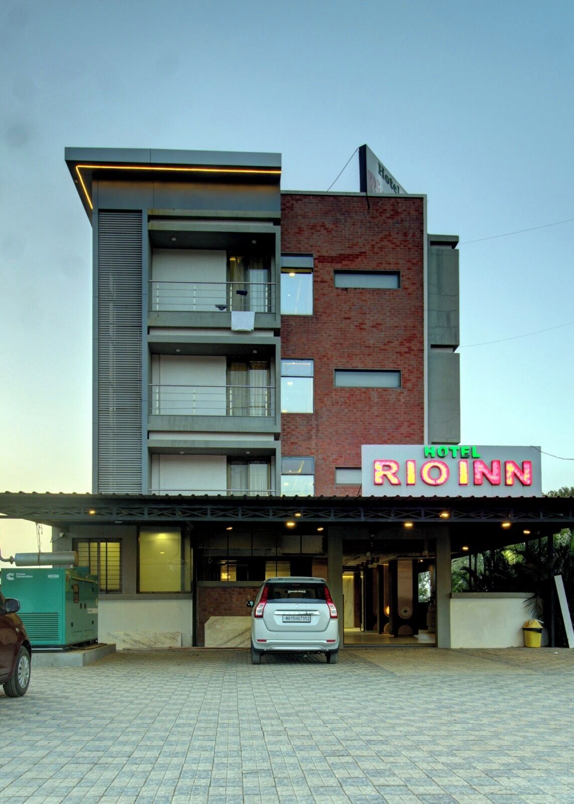 A hotel named RIO INN with a modern design, featuring a brick facade and a flat roof.