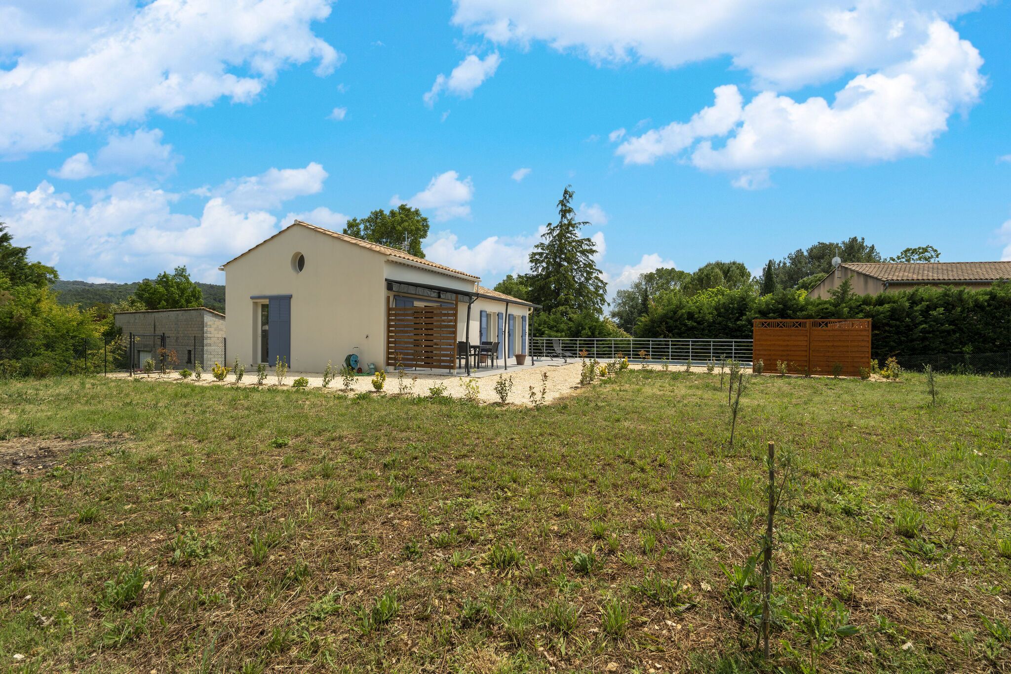 Een modern huis met een ruime garage, een overdekte patio en een omheinde tuin.