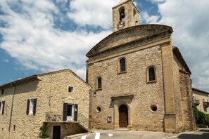 A stone building with a bell tower, arched windows, and a door.