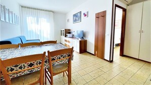 Un espacio habitable compacto con comedor, kitchenette y armario.