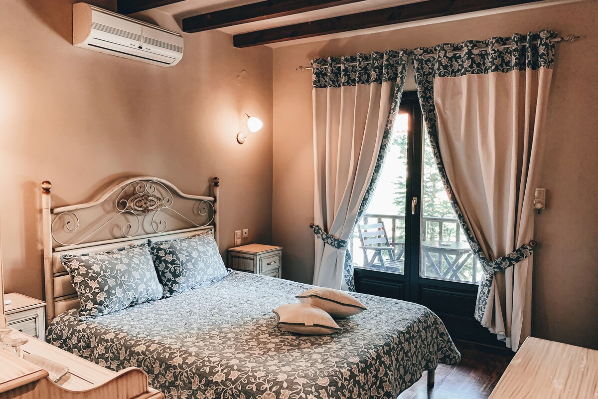 A bedroom with a bed, bedside table, and a window with curtains.