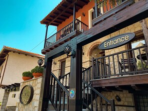 A building with a sign reading "Entrance" and another sign for "Guest House Elena Senonales." - Guesthouse Elena (Kalabaka)