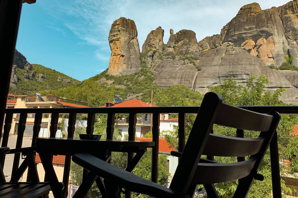 Un balcón con vistas a formaciones rocosas y edificios.