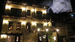 A stone building with a reception area and a sign indicating a guest house named Elena Benonaz. - Guesthouse Elena (Kalabaka)
