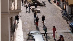 A cobblestone street with historic buildings, a fountain, and people walking. - Residenza Cappello (Verona)