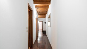 A hallway with wooden flooring and white walls. - Residenza Cappello (Verona)