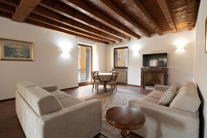 Una sala de estar con dos sofás, una mesa de centro de madera, una chimenea y un televisor.